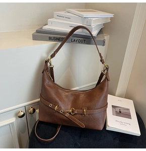 Dettagli della borsa sottobraccio marrone scuro vintage con fibbia dorata e texture pelle