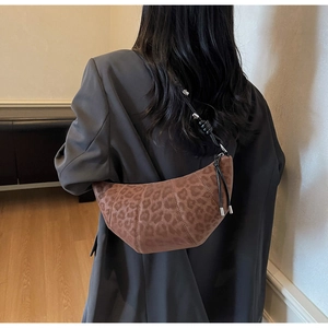 Detail of leopard print croissant bag with woven strap and silver adjustable buckle