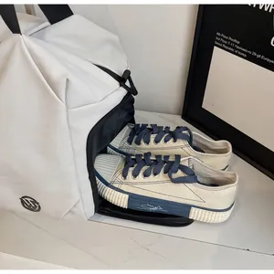 Detail showing the bottom independent shoe compartment of the white travel sports bag