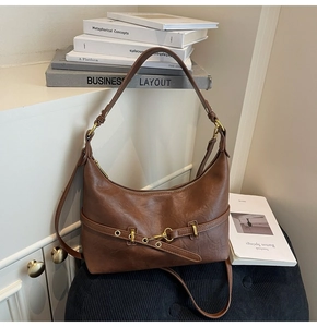 Dettaglio borsa hobo in pelle marrone vintage con fibbia dorata e doppia tracolla