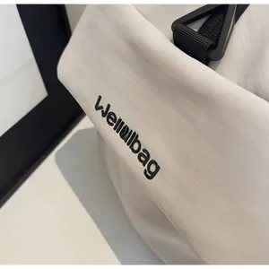 Close-up of waterproof fabric detail with Weilabag logo and black buckle on beige gym bag