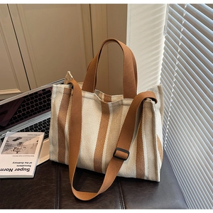 Detail of striped canvas tote bag showing woven texture and adjustable shoulder strap