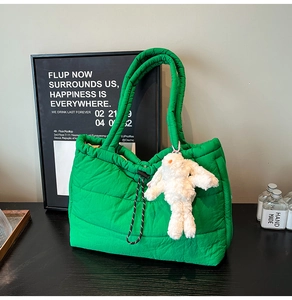 Detail showing bright green quilted tote bag with drawstring closure and bunny charm