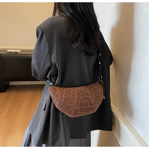 Detail of vintage leopard print crescent bag with suede texture and slim strap