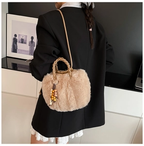 Detail der flauschigen beigen Beuteltasche mit Webpelz und Anhänger aus Holzperlen