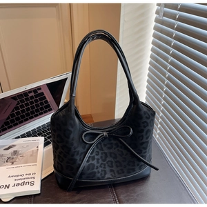 Detail of black leopard print tote bag with bow accent and long shoulder handles