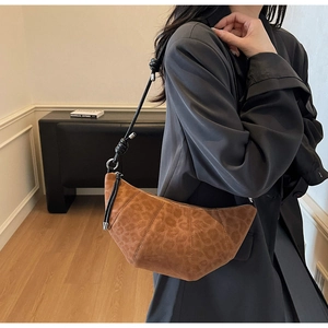 Detail of a brown leopard print croissant bag in matte suede with a knotted black strap