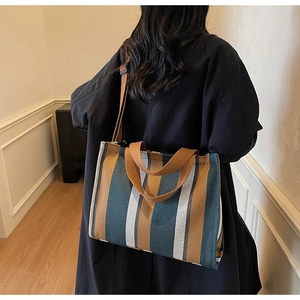 Detailed shot of large striped canvas tote bag with adjustable brown shoulder strap