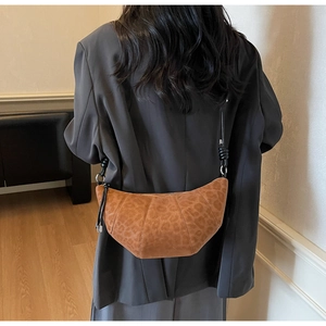 Detailed view of the leopard print suede croissant bag showing texture and crescent shape