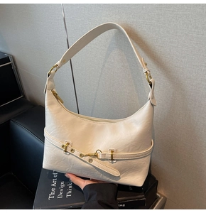 Dettaglio della borsa hobo in pelle bianco crema con cinturino e fibbia in metallo dorato