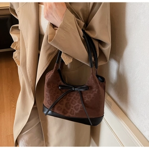 Detail of leopard print tote bag with black leather bow and stylish shoulder strap