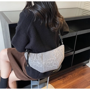 Model view of grey leopard print crescent bag showing crossbody strap and knot detail