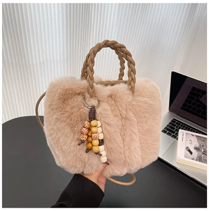 Detail der Plüsch-Beuteltasche mit geflochtenen Ledergriffen und Vintage-Holzperlenquaste
