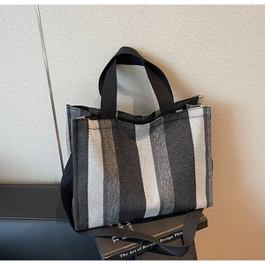 Macro shot of vertical striped woven fabric texture on canvas tote bag with black strap