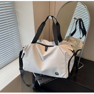 Detail of a large white travel bag with black straps and logo on a metal hanger