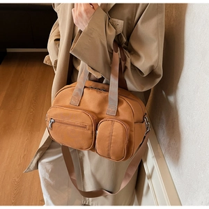 Detail of earthy brown canvas tote bag with multi-pocket layout and adjustable strap
