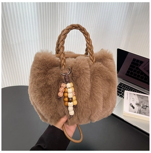 Detailaufnahme der braunen Plüschtasche aus Kunstpelz mit Webgriff und Perlenquasten-Anhänger