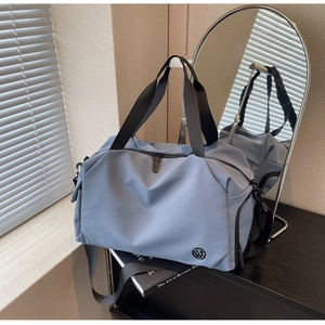 Detailed view of gray-blue waterproof travel bag with logo and adjustable shoulder strap