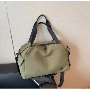 Detail of durable olive green travel bag showing sturdy straps and circular logo design