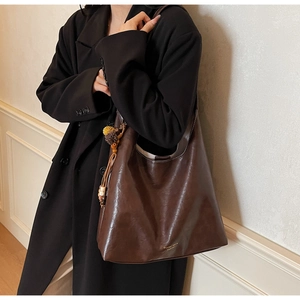 Brown vintage faux leather tote bag with tassels and gold Shantell Katie brand lettering