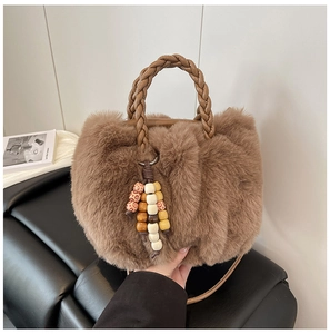 Detailansicht der braunen Plüschtasche mit geflochtenem Ledergriff und Perlenquasten