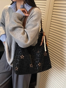 Sac cabas léopard noir avec découpes de fleurs et bandoulières en cuir marron élégant