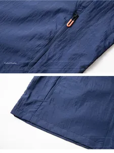 Detail of navy windbreaker showing hidden zipper pocket and reinforced double-stitched hem