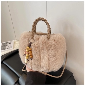 Detail der flauschigen khakifarbenen Beuteltasche mit Webgriff und Perlenanhänger