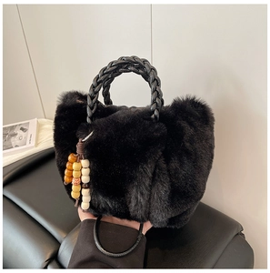 Detailansicht einer schwarzen Kunstfell-Beuteltasche mit Flechtgriff und Perlen-Quaste