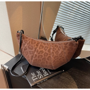 Detail of vintage leopard print half-moon bag with woven strap and silver zipper closure