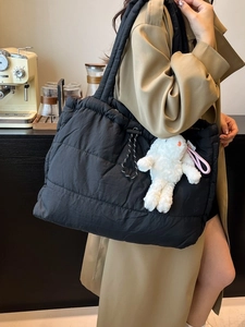 Quilted black puffer tote bag for women with plush rabbit charm and drawstring top