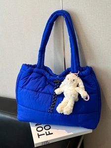 Electric blue quilted puffer tote bag with plush rabbit pendant and padded straps