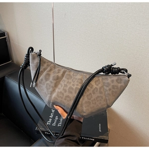 Detail of grey leopard print croissant bag featuring knotted rope strap and silver hardware