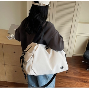 Detail of a beige multi-functional sports bag featuring black straps and side buckles