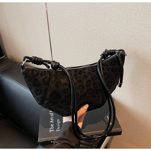 Close-up of matte black leopard print hobo bag with unique knotted strap detail