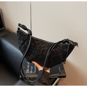 Detail of black leopard print suede croissant bag with knotted shoulder strap design
