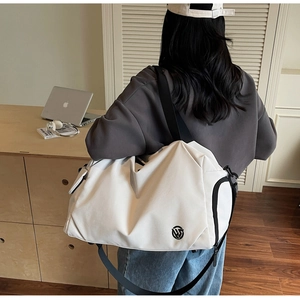 Minimalist white gym bag with black straps in a lifestyle setting on shoulder
