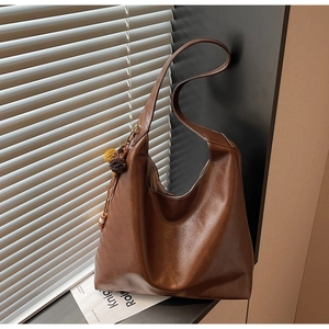 Detailed macro of vintage brown tote bag texture and color-blocked tassel accessory