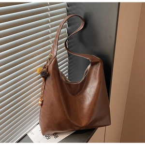Detail of vintage brown tote bag texture and decorative tassels on the side