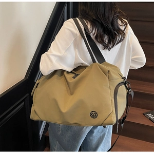 Detail of travel bag side zipper pocket and wide nylon shoulder strap on durable fabric