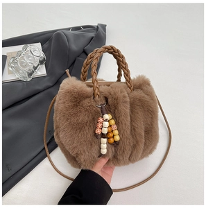 Detailansicht der braunen Plüschtasche mit geflochtenem Griff und Perlenanhänger