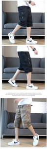 Detailed view of men's loose camouflage cargo shorts with side zipper pockets and straps