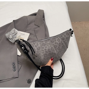 Detail of grey leopard print croissant bag with woven rope strap and silver hardware
