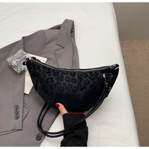Detailed view of black leopard embossed crescent bag with unique knot detail on the strap
