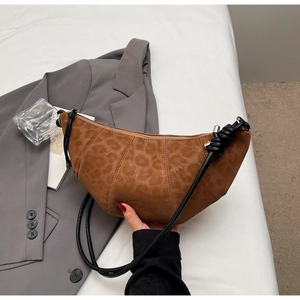 Close-up of brown leopard pattern texture and knot detail on a matte finish crescent bag