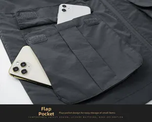 Close-up of functional flap pockets on dark grey cargo vest holding two smartphones