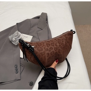 Detail of leopard print half-moon bag with quilted texture and woven strap detail