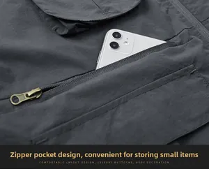Close-up of durable dark grey fishing vest featuring secure zipper pocket and phone storage