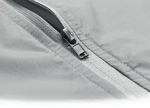 Close-up of durable gray zipper and textured quick-dry fabric on men's outdoor vest