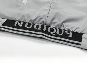 Detail of grey athletic vest showing black ribbed hem with white letter print design